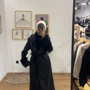 Manteau long noir avec col et manches en fourrure